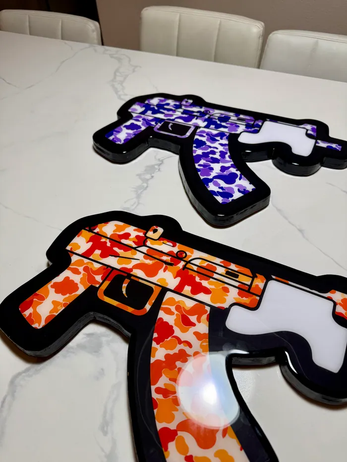 Orange and purple camouflage rifle pieces on a marble table