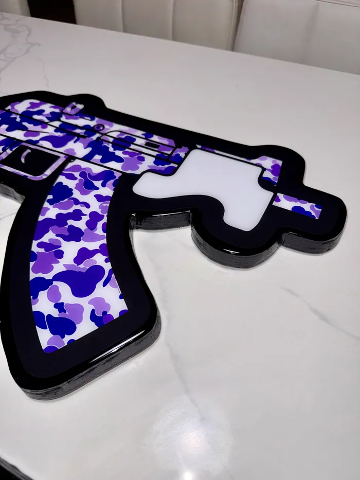 A purple camouflage rifle piece in glossy epoxy on a marble table