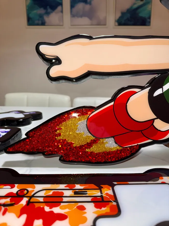 Close-up of a red and gold glitter rocket flame under clear epoxy